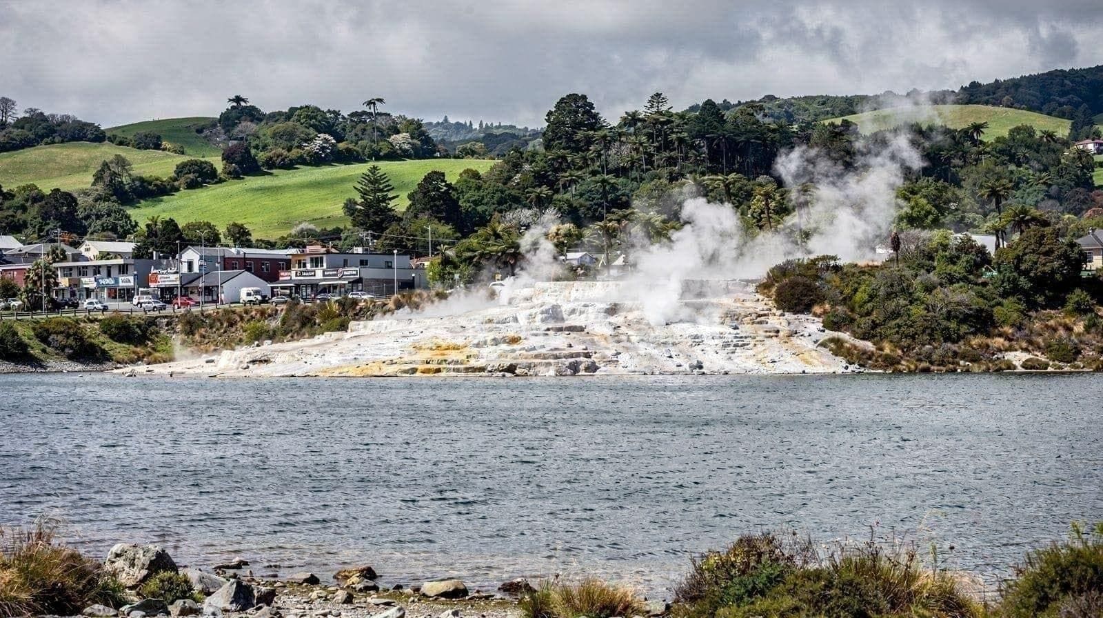 Dampf steigt in der Abenddämmerung über dem geothermalen Tal von Te Puia auf